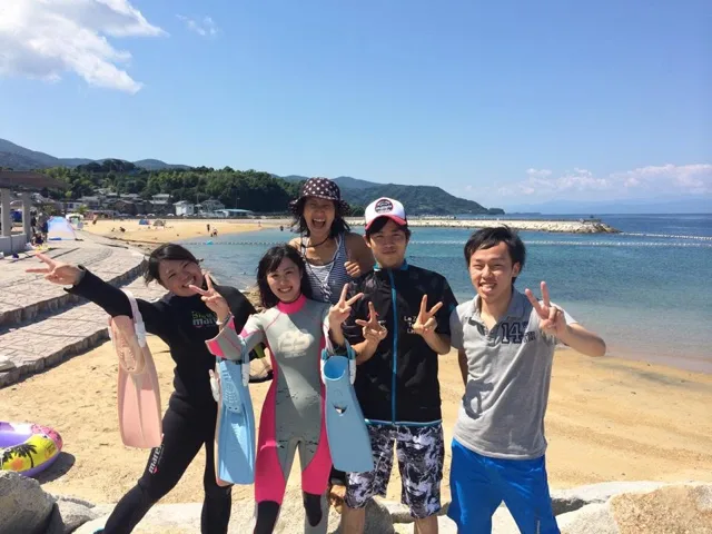 海辺で記念撮影するBIG BLUEの参加者(2014年)