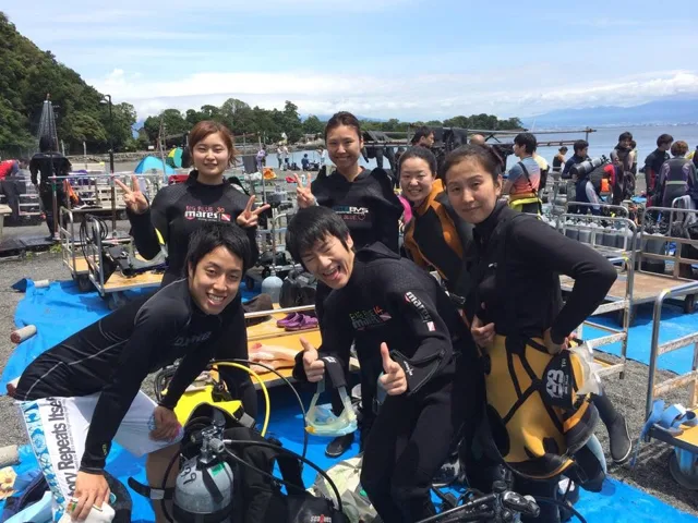 海辺で記念撮影するBIG BLUEの参加者(2015年)
