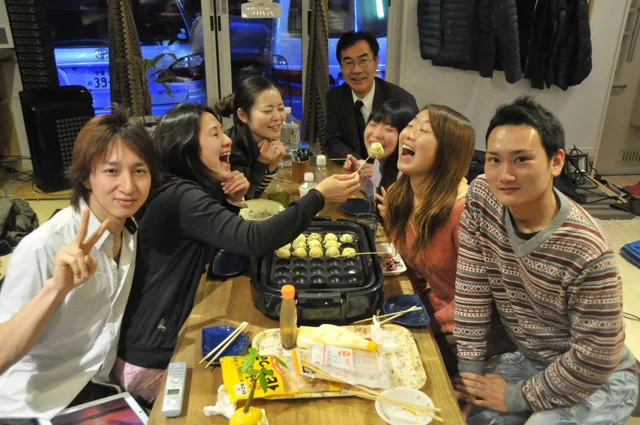 室内で飲み物を持って集まる参加者(2012-2013年)
