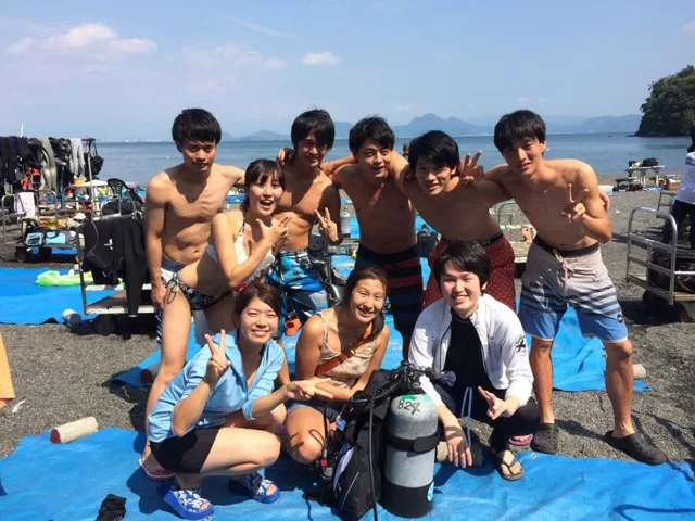 海辺で記念撮影するBIG BLUEの参加者(2015年)