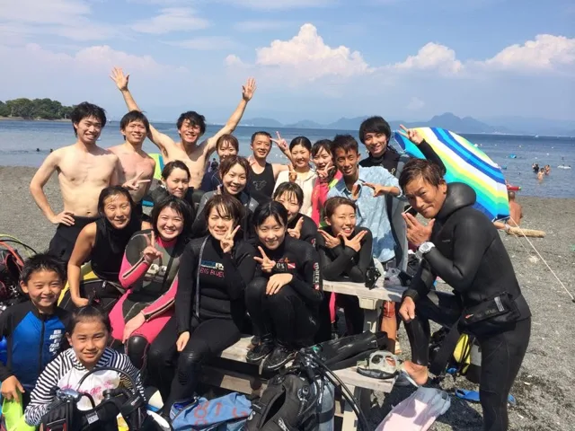 海辺で記念撮影するBIG BLUEの参加者(2015年)