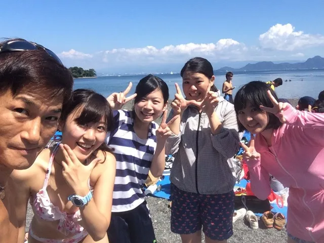 海辺で記念撮影するBIG BLUEの参加者(2015年)