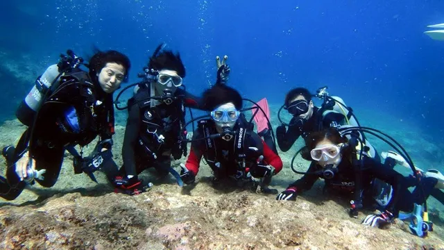 海底で並んで記念撮影するダイバー(2015年)