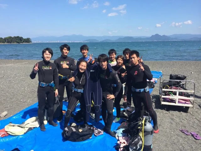 海辺で記念撮影するBIG BLUEの参加者(2015年)