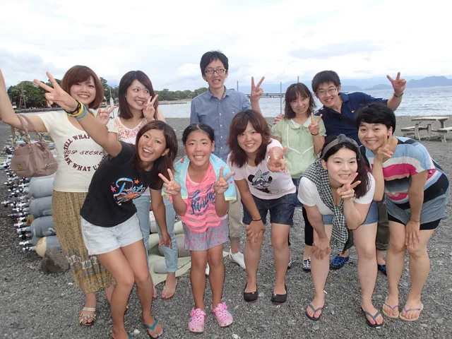 海辺で記念撮影するBIG BLUEの参加者(2012-2013年)