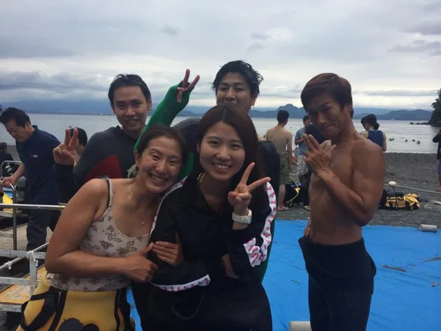 海辺で記念撮影するBIG BLUEの参加者(2015年)