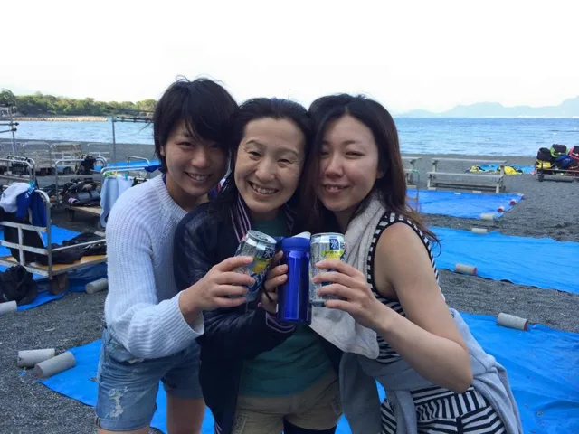 海辺で飲み物を持つ参加者(2015年)