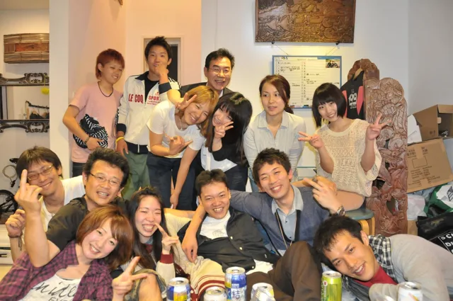 室内で食事を囲んで記念撮影する参加者(2012-2013年)