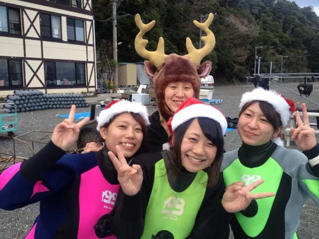 海辺で季節の飾りを身に着けた参加者(2012-2013年)