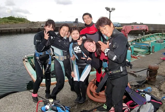 海辺で記念撮影するBIG BLUEの参加者(2015年)