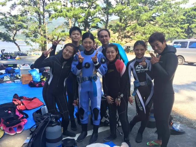 海辺で記念撮影するBIG BLUEの参加者(2015年)