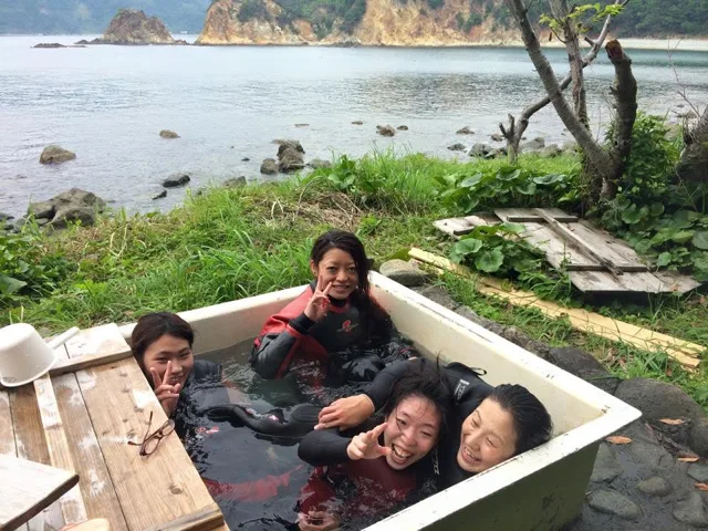 海を背景に木製のベンチでくつろぐ参加者(2015年)