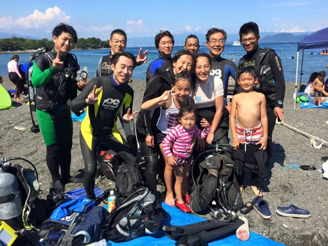 海辺で記念撮影するBIG BLUEの参加者(2015年)