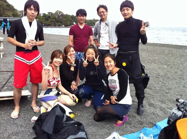 伊豆・大瀬崎でのダイビング：海辺で並ぶ参加者の集合写真