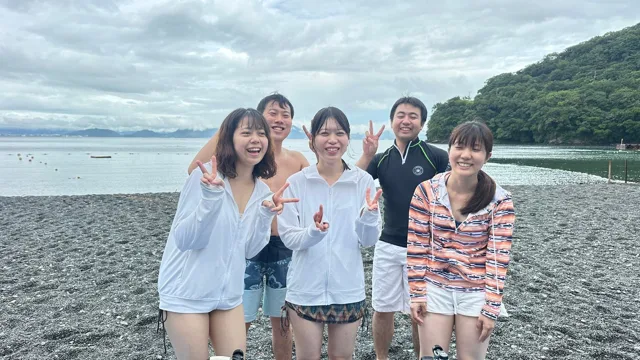 伊豆・大瀬崎でのダイビング：海辺で並ぶ5人の参加者