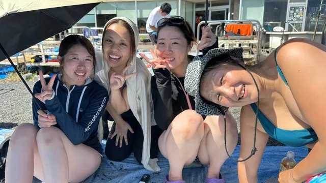 伊豆・大瀬崎でのダイビング：海辺で笑顔を見せる4人の参加者