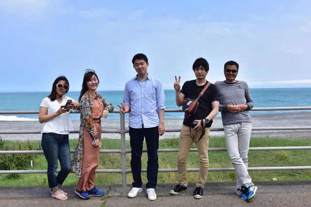 ダイビングツアー中に海を背景に並ぶ参加者