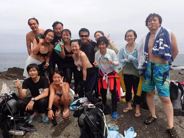 秋の浜での4人以上の参加者の集合写真