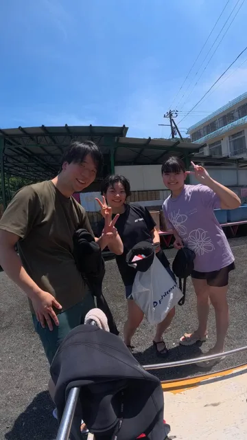 ダイビング器材の前で記念撮影する3人の参加者