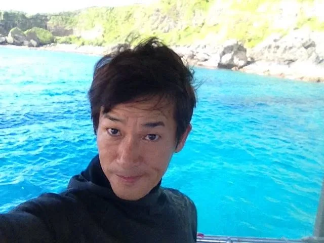 鹿児島県・沖永良部島での沖永良部島の青い海を背景にしたツアー参加者