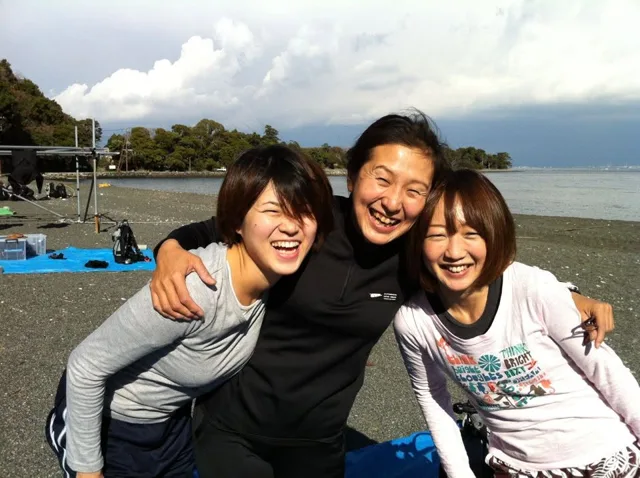 伊豆・大瀬崎でのダイビング:大瀬崎の海辺で記念撮影する3人のダイビング参加者