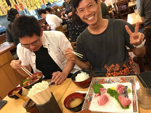 海のツアーの食事で海鮮丼と定食を楽しむ2人の参加者(元アルバムから推定)