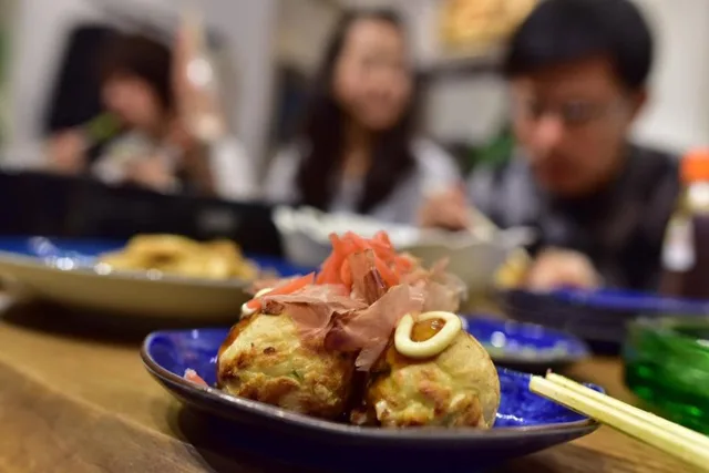 たこ焼きパーティーで取り分けたたこ焼きと集まった仲間