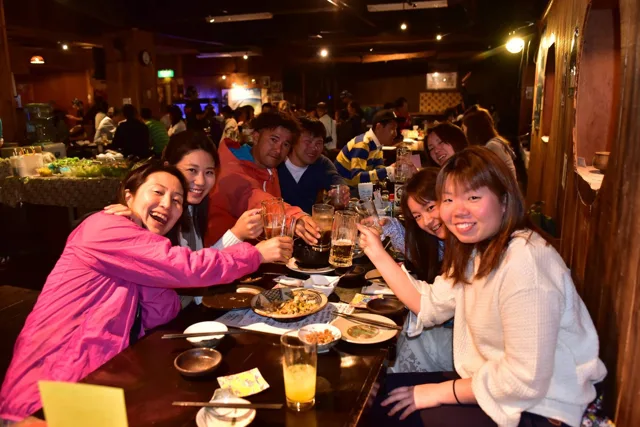 沖縄県・宮古島での宮古島ツアーの食事で料理と飲み物を囲む参加者