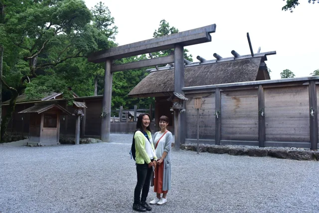 神社名・撮影場所未確認（越前ツアー中の参拝）での越前ツアーの参拝中、木造の鳥居と社殿の前で並ぶ参加者