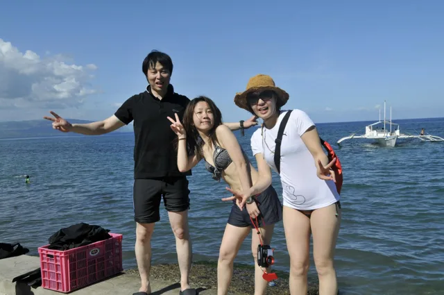 フィリピン（アポ島・スミロン島・ドゥマゲッティ方面、地点未確認）でのフィリピンダイビングツアーの海を背景に並ぶ3人の参加者