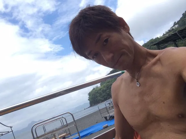 伊豆・大瀬崎でのダイビング:大瀬崎の海を背景に写るダイビング参加者