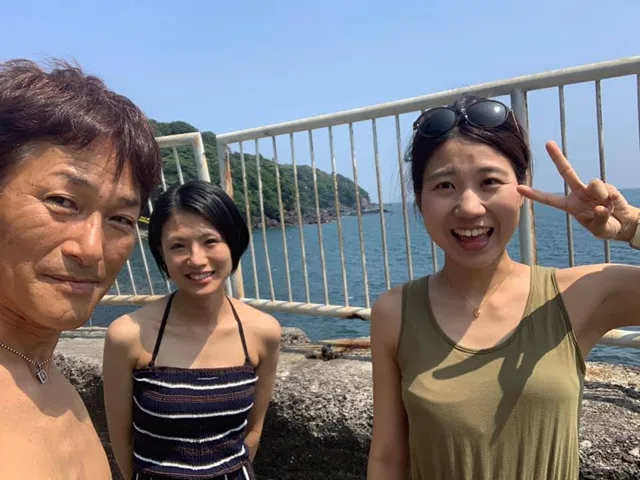 湯河原町・福浦での青空と福浦の海を背景に記念撮影する参加者